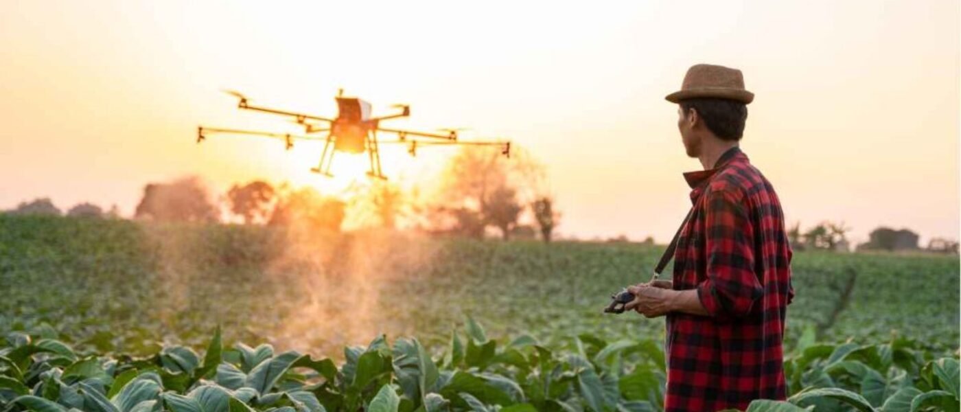 Farmer in field flying a agricultural drone The Pros And Cons Of Agriculture Drone In Agriculture